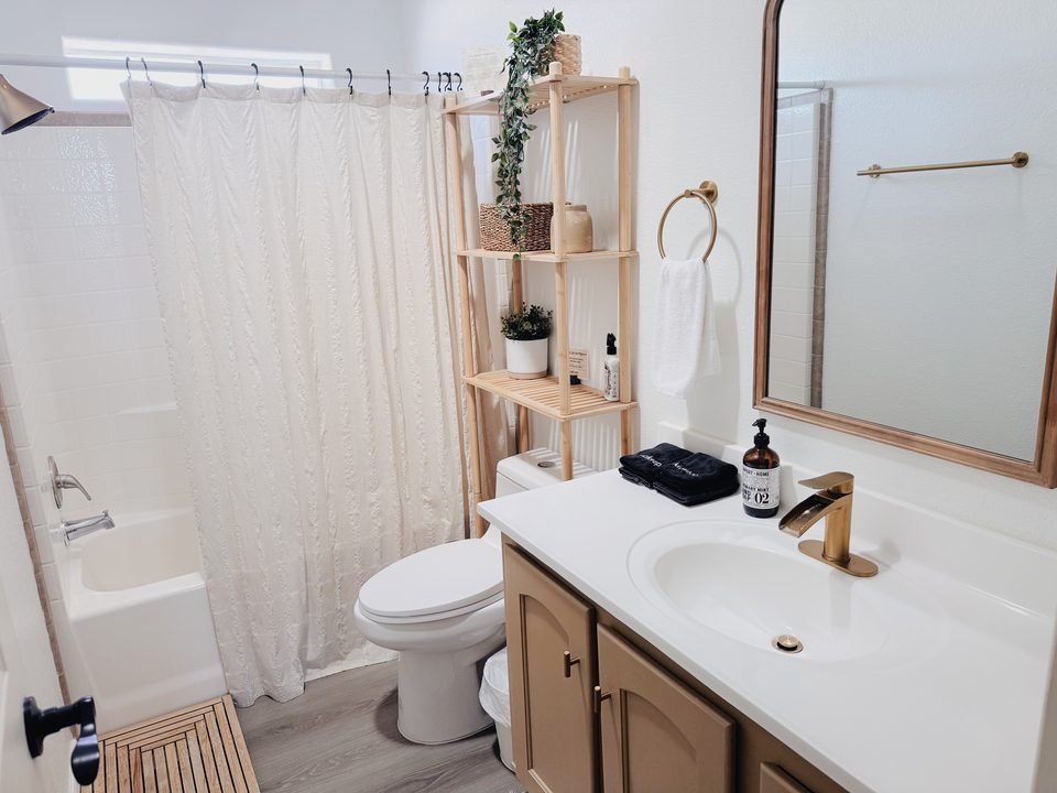 Bathroom with tub, shower and gold fixtures