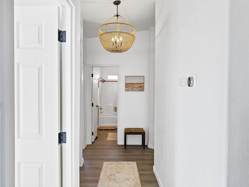 Hallway with chandelier leading to the bedrooms