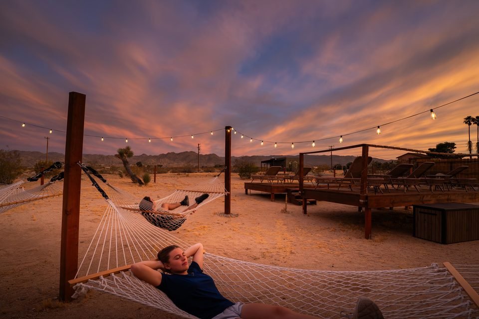 Guests in the hammocks under a sunset sky
